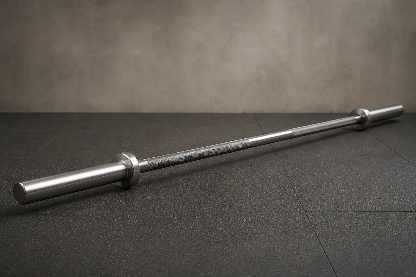 A plain unbranded deadlift bar with a long thin shaft, resting on a gym floor.