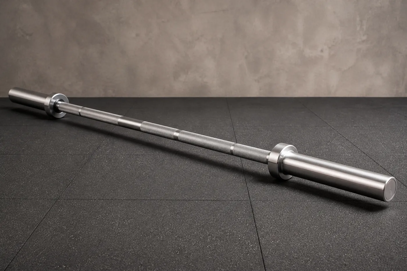 A plain unbranded power bar with a thick straight shaft, resting on a gym floor.